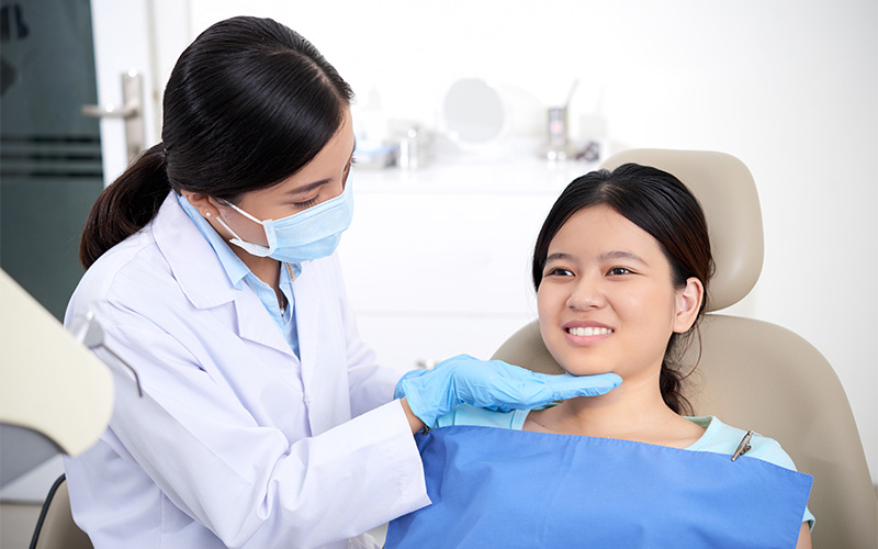 Dentist examining patient in clinic.