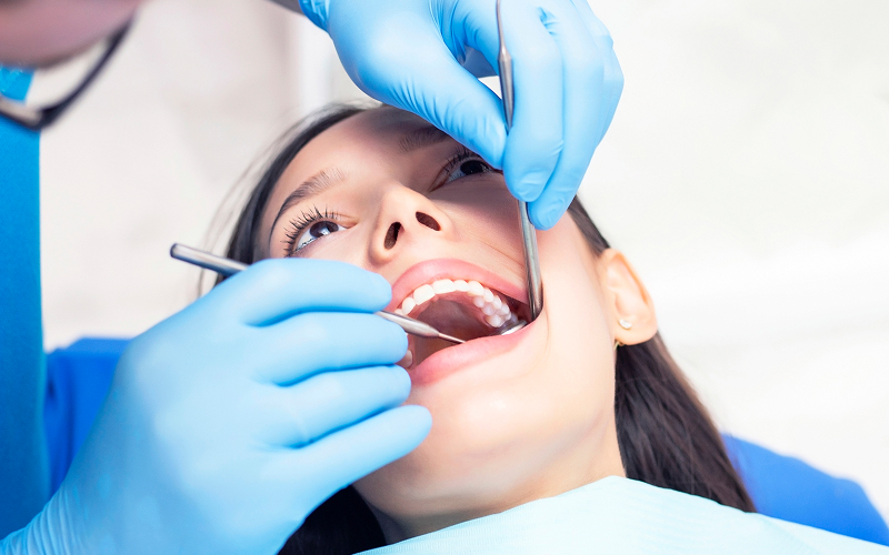 Dentist-examining-a-female-patients-teeth-for-chipped-tooth-care